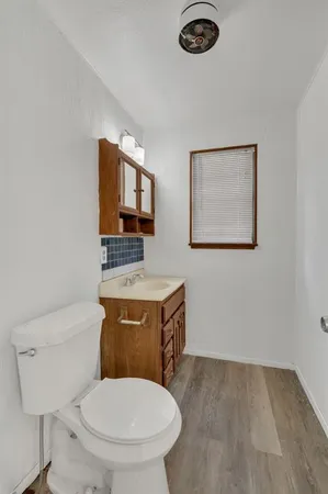a bathroom with a toilet a sink and mirror