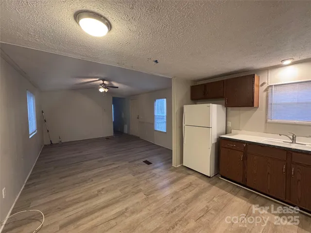 a view of a kitchen with a sink and a refrigerator