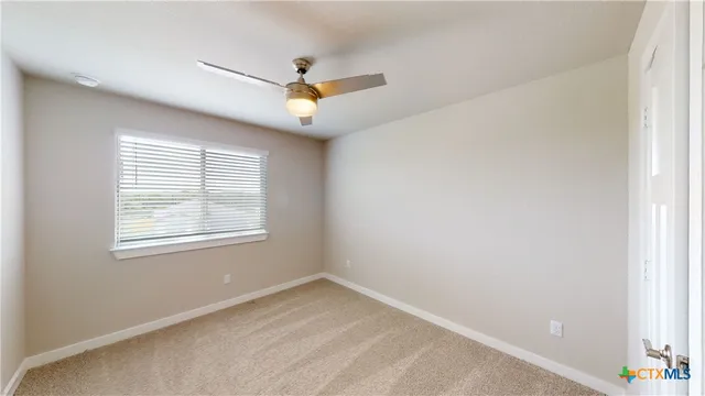 a view of a livingroom with a ceiling fan and window