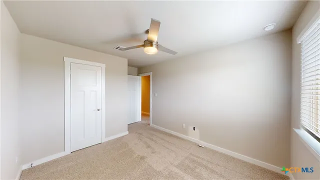 a view of empty room with ceiling fan