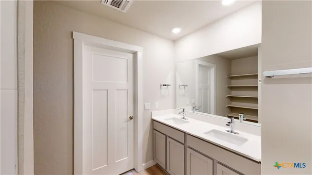 a bathroom with a sink double vanity and a mirror