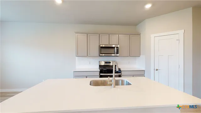 a kitchen with granite countertop a sink a stove and microwave