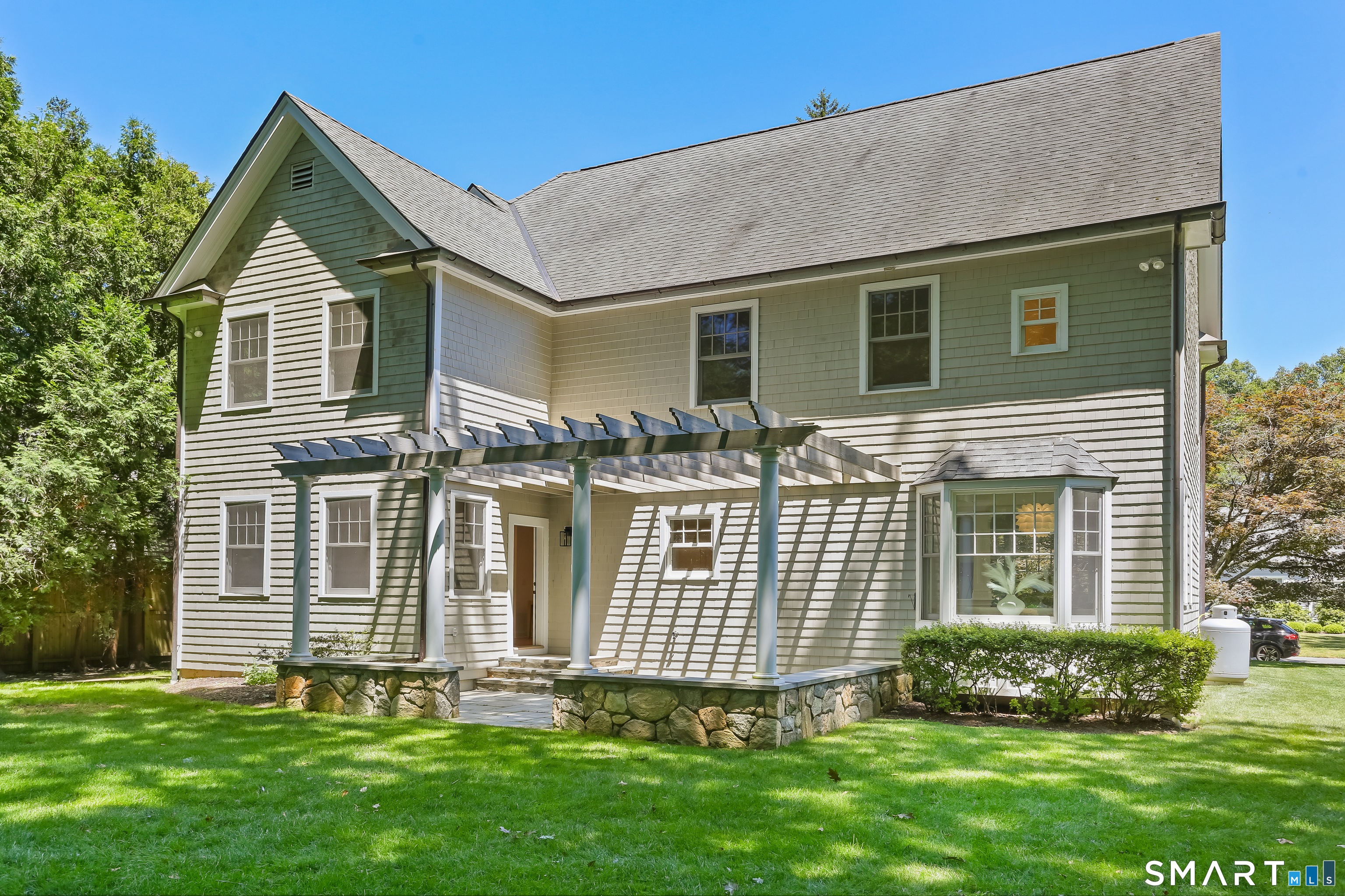 21 Woods Grove Road Westport, CT 06880 - Photo 34 of 38 View of the back of the house shwoing the Terrace with pergola