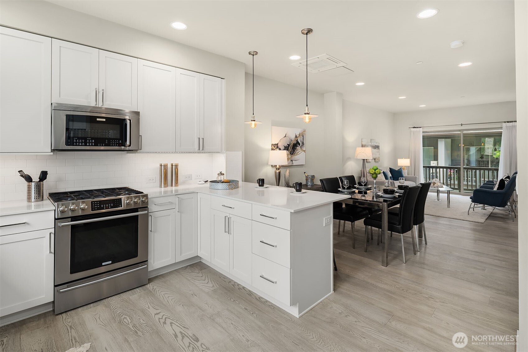 1910 Riva Lane Northwest Issaquah, WA 98027 - Photo 12 of 31 a open kitchen with stainless steel appliances kitchen island granite countertop a stove top oven a sink dishwasher a dining table and chairs with wooden floor