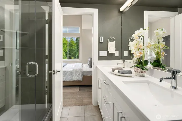 a en suite bathroom with a double vanity sink a mirror and shower