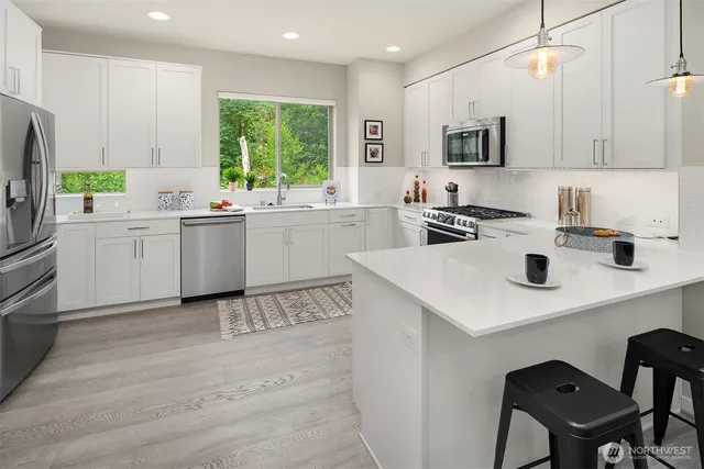 a kitchen with a stove a sink a microwave and cabinets