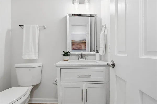 a bathroom with a toilet sink vanity and mirror