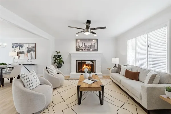 a living room with furniture a fireplace and a large window