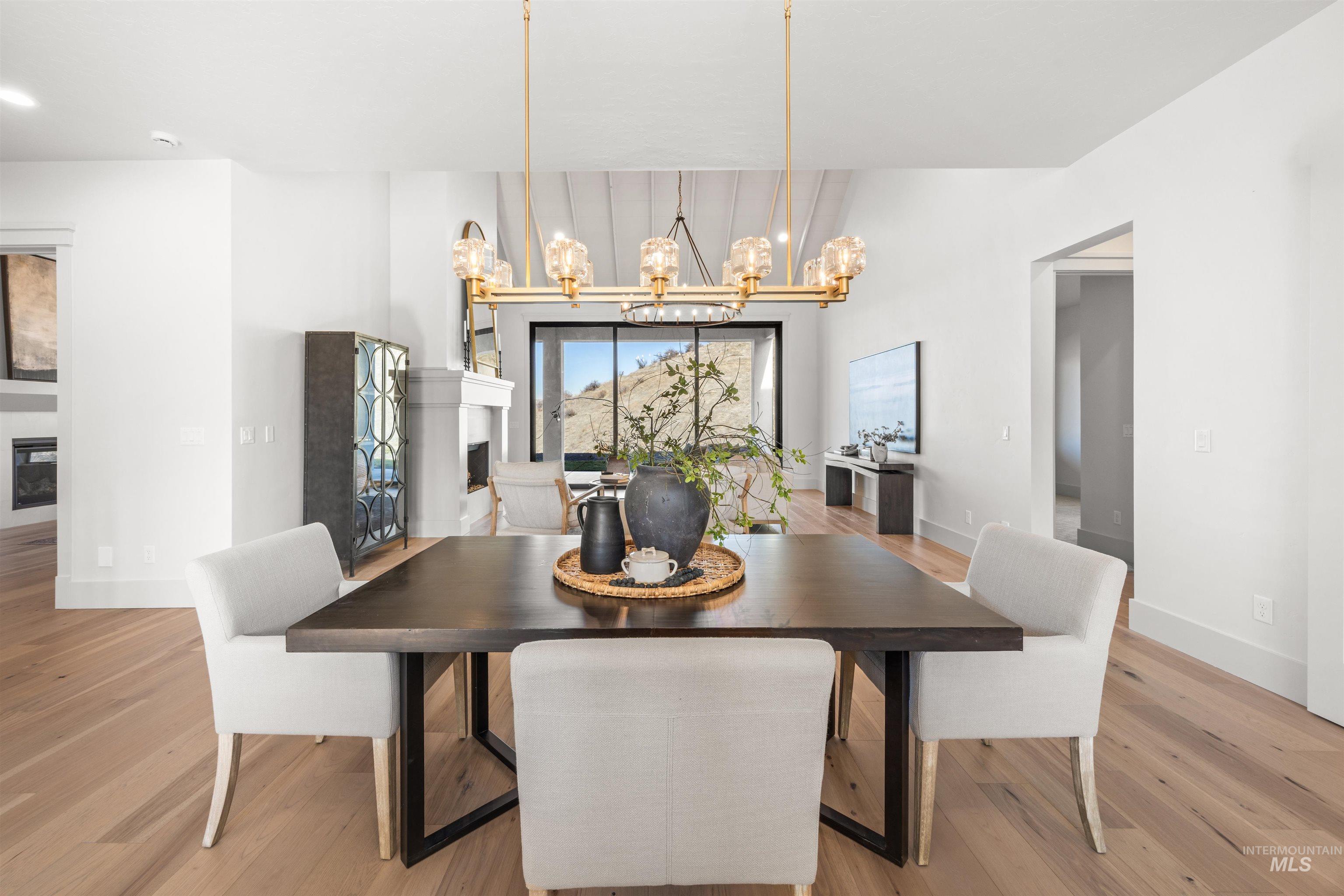 10968 North Elk Ridge Place Boise, ID 83714 - Photo 13 of 49 Dining area with a fireplace, light wood-style floors, and suspended lighting