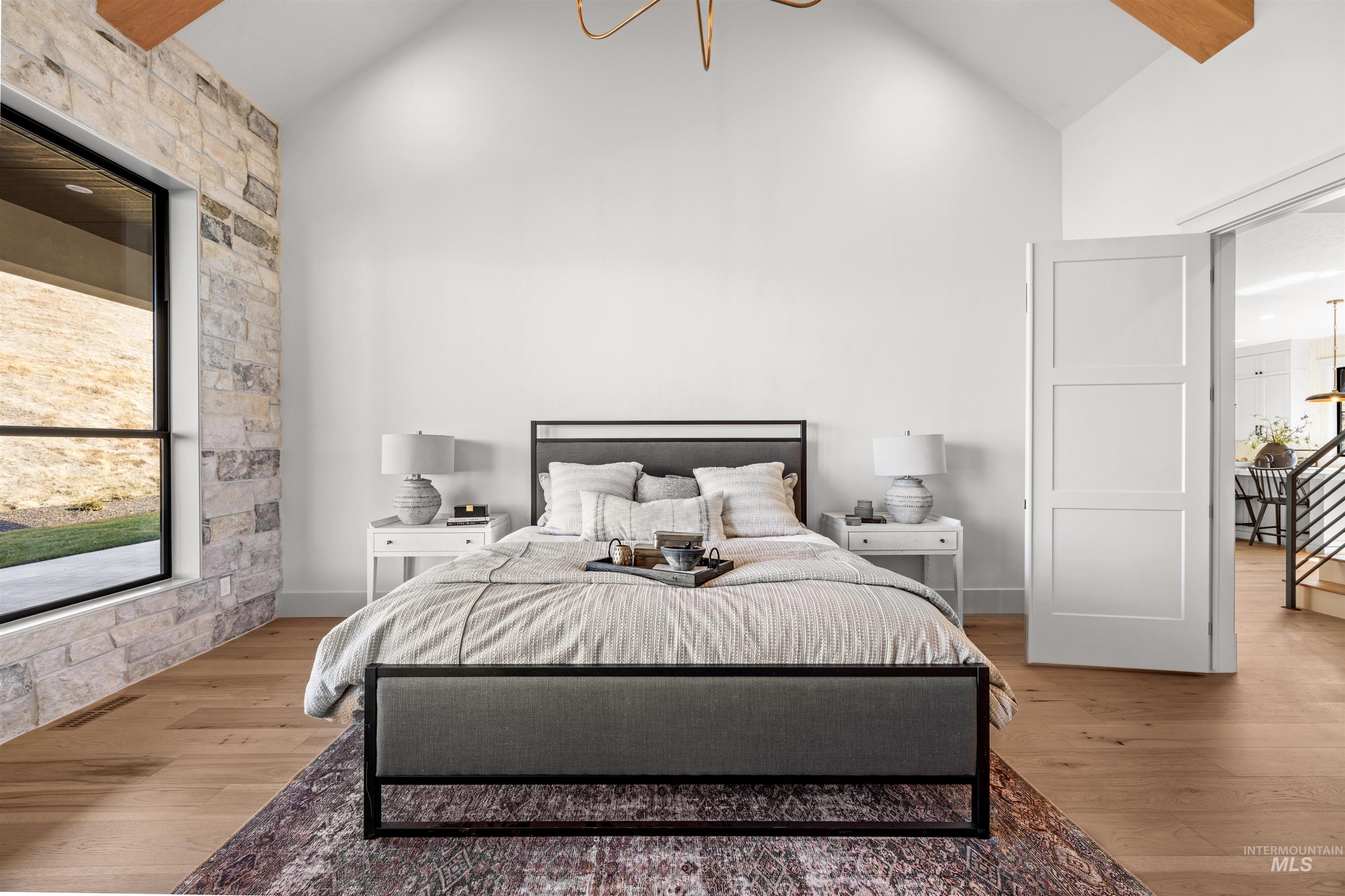 10968 North Elk Ridge Place Boise, ID 83714 - Photo 23 of 49 Bedroom with multiple windows, lofted ceiling, suspended lighting, and wood finished floors