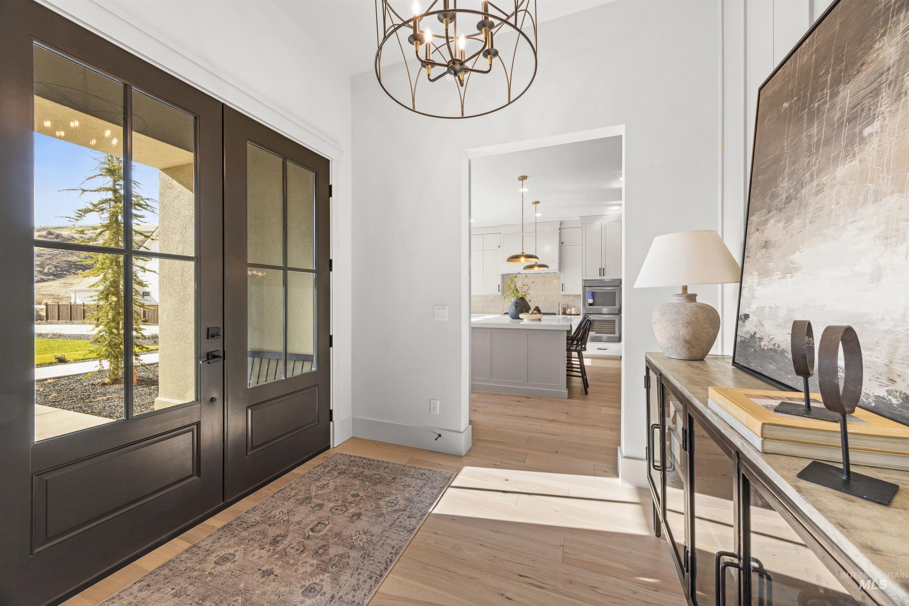 10968 North Elk Ridge Place Boise, ID 83714 - Photo 5 of 49 Foyer with light wood-style floors, hanging lights, french doors, and healthy amount of natural light