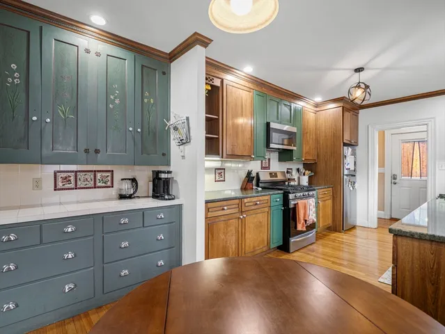 a kitchen with stainless steel appliances granite countertop a stove a sink and a refrigerator