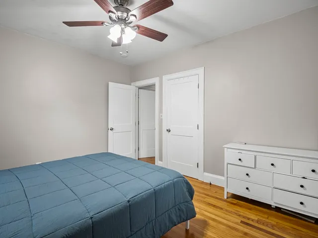 a bedroom with a bed and a chandelier fan