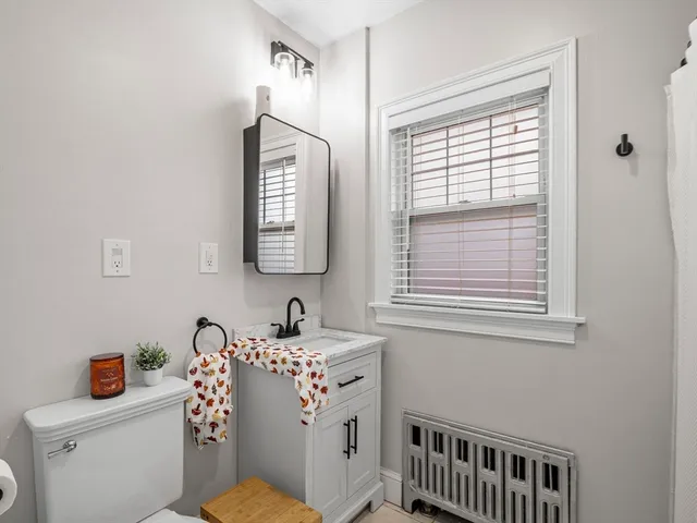 a bathroom with a sink a toilet and a window
