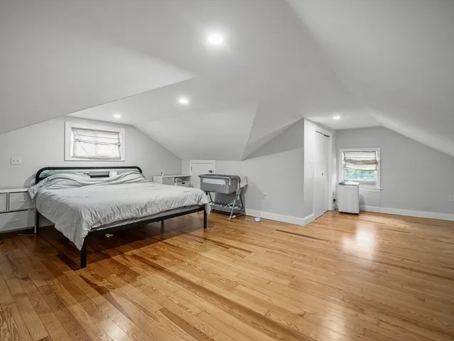 a bedroom with a bed and wooden floor