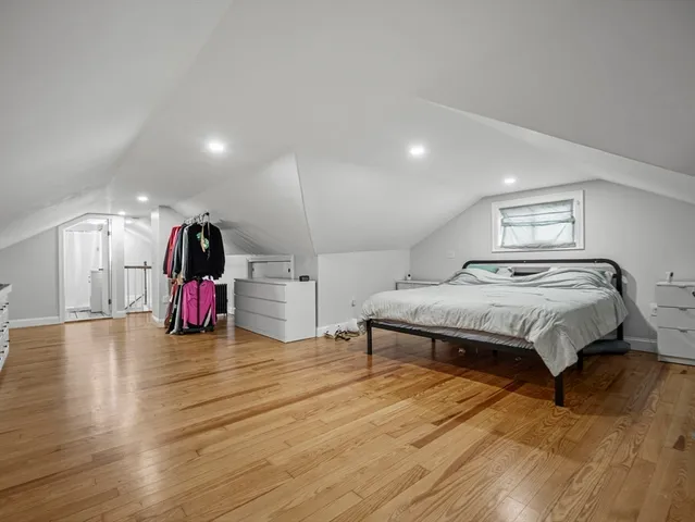 a spacious bedroom with a bed and a view of kitchen