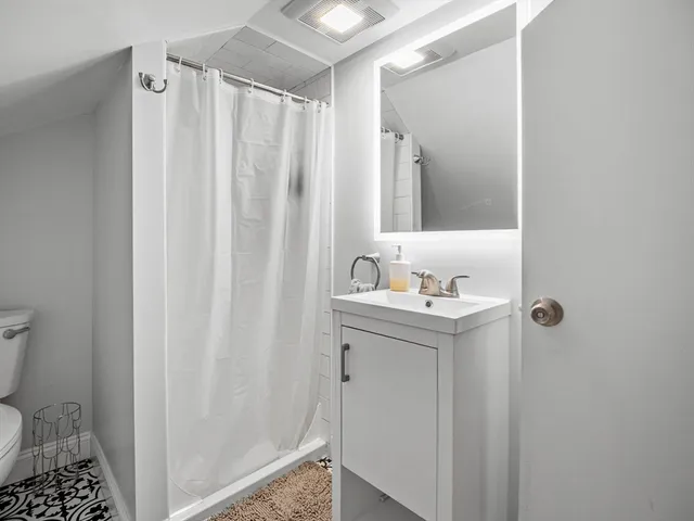 a bathroom with a sink a toilet and shower