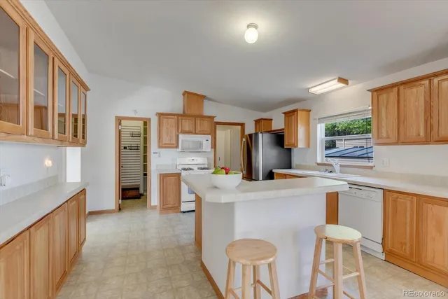 a kitchen with stainless steel appliances a table and chairs in it