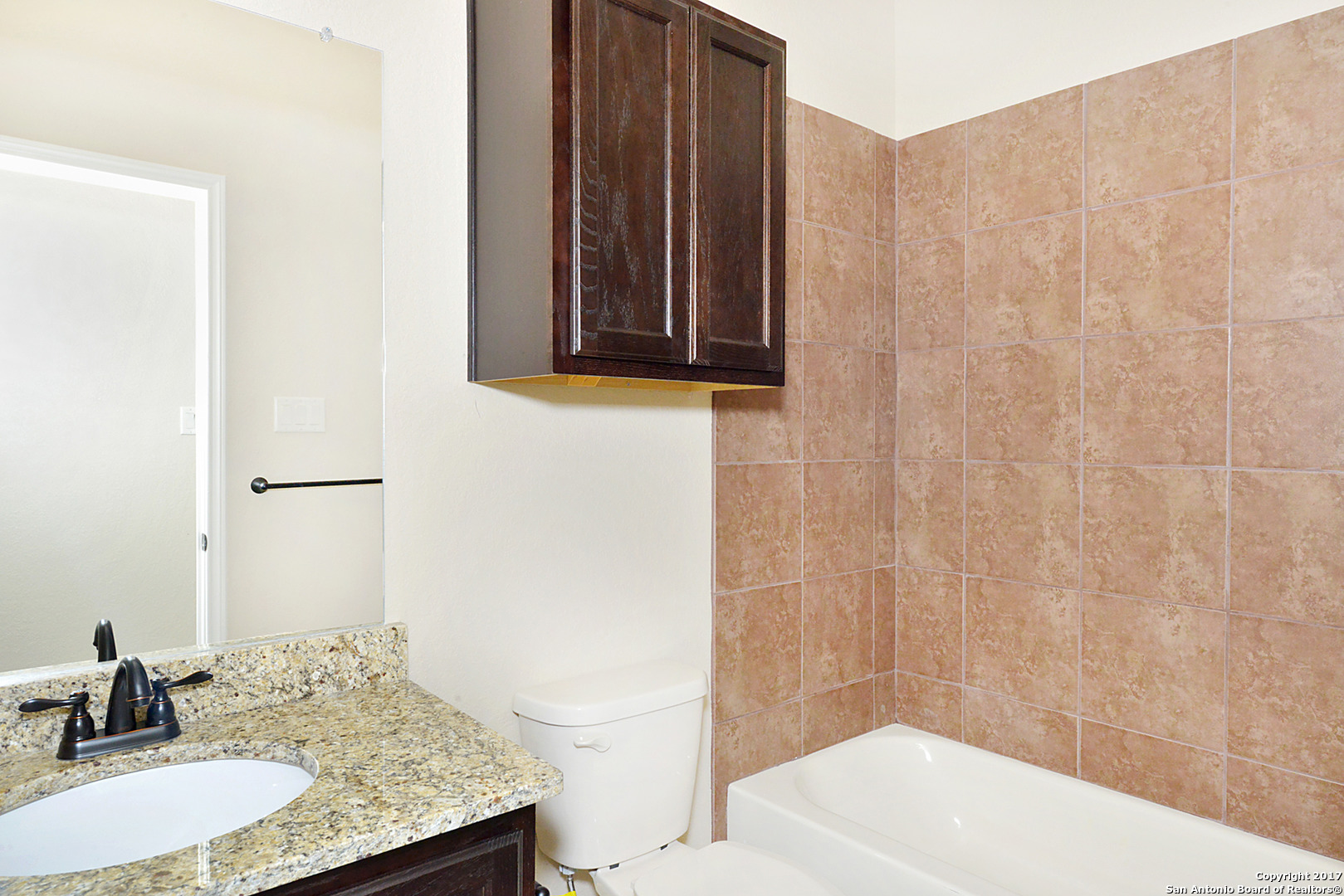 2557 Pahmeyer Road New Braunfels, TX 78130 - Photo 20 of 25 a bathroom with a granite countertop sink a toilet and mirror