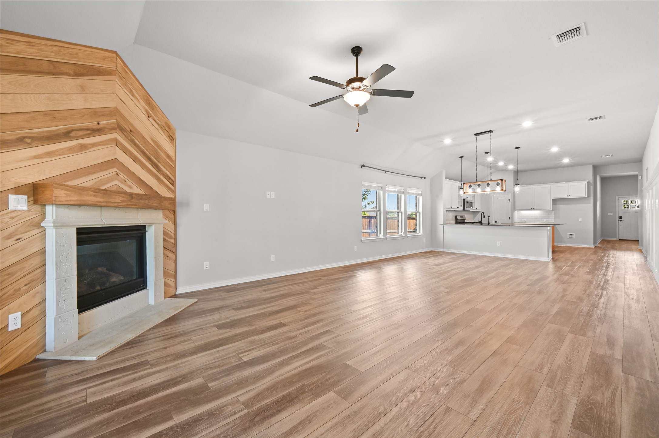 426 Cold Riv Run Kyle, TX 78640 - Photo 15 of 34 Bright, open-concept living area with a contemporary fireplace and soaring vaulted ceilings.