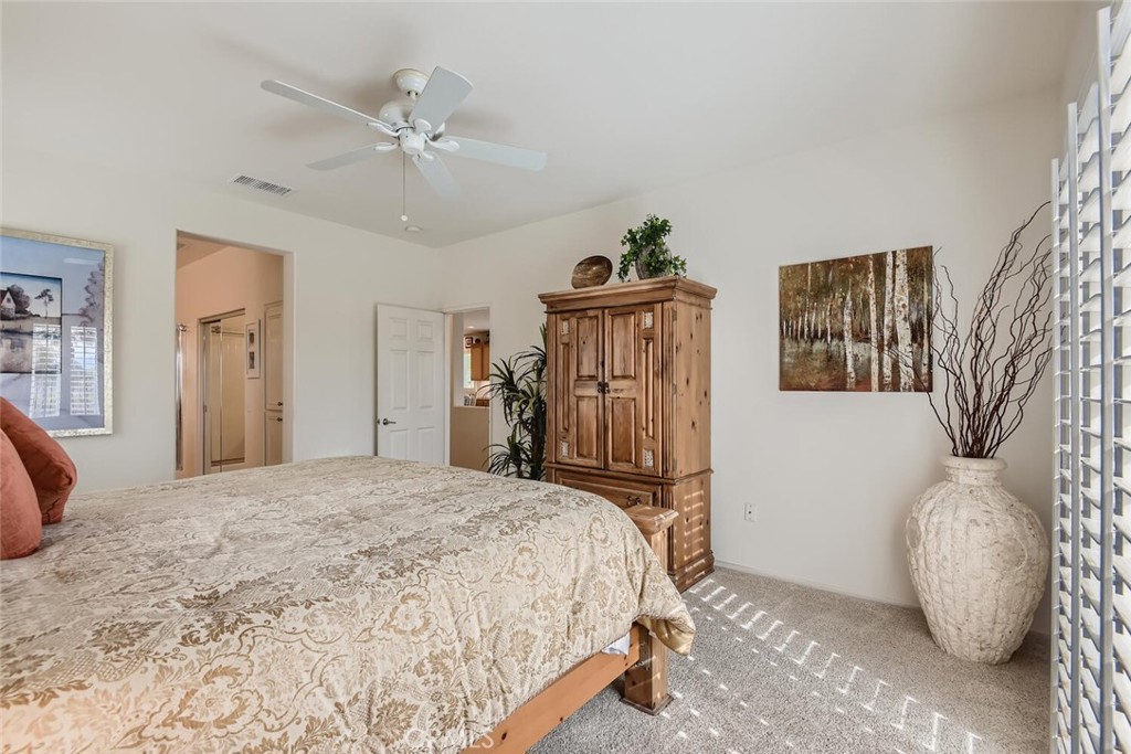 28517 Oasis View Circle Menifee, CA 92584 - Photo 19 of 66 a bedroom with a bed and a chandelier
