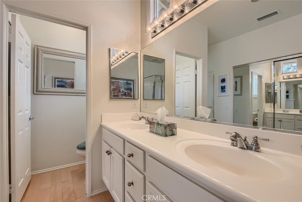 28517 Oasis View Circle Menifee, CA 92584 - Photo 22 of 66 a bathroom with a double vanity sink and a mirror