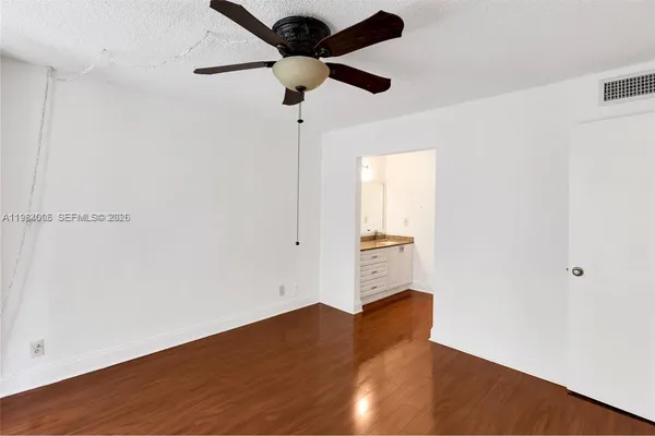 a view of an empty room with wooden floor
