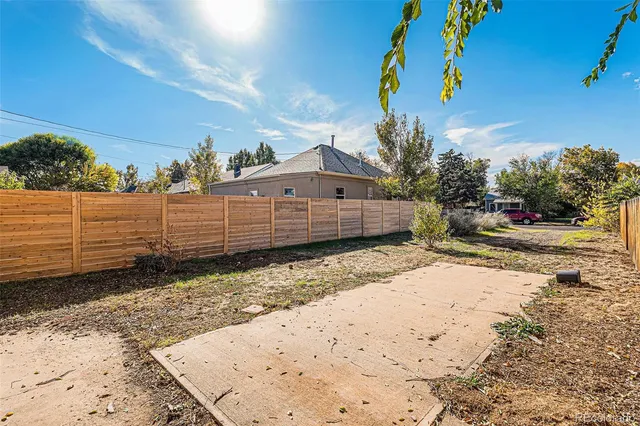a backyard of a house with a table and chairs