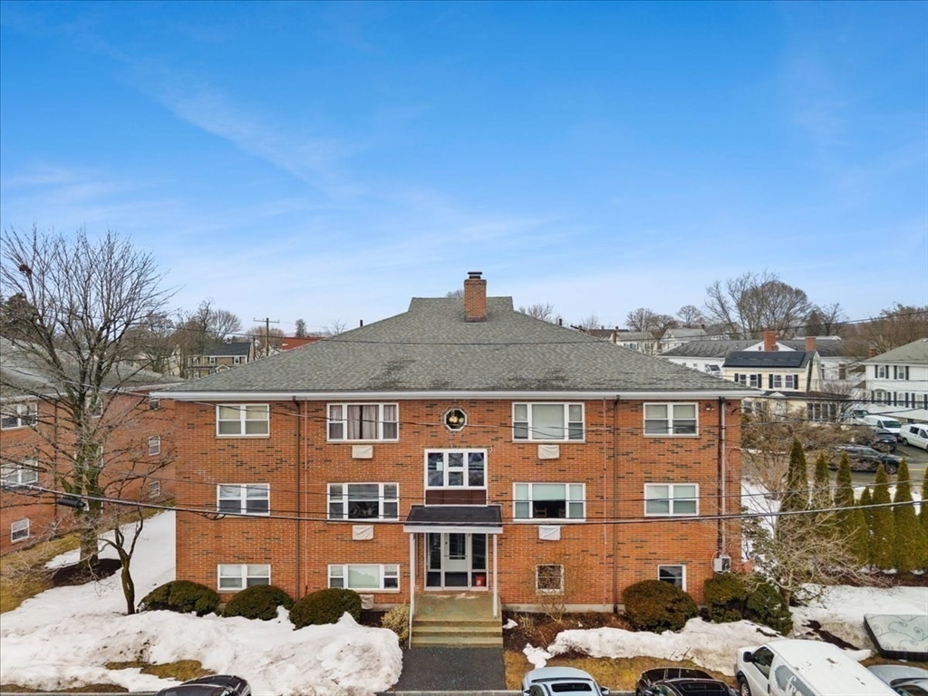 51 Warren Street, Unit 13 Waltham, MA 02453 - Photo 12 of 16 a front view of a residential apartment building with a yard
