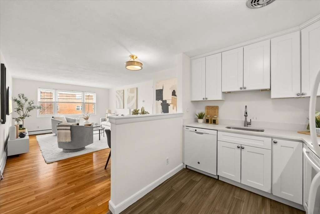 51 Warren Street, Unit 13 Waltham, MA 02453 - Photo 2 of 16 a kitchen with sink cabinets and wooden floor