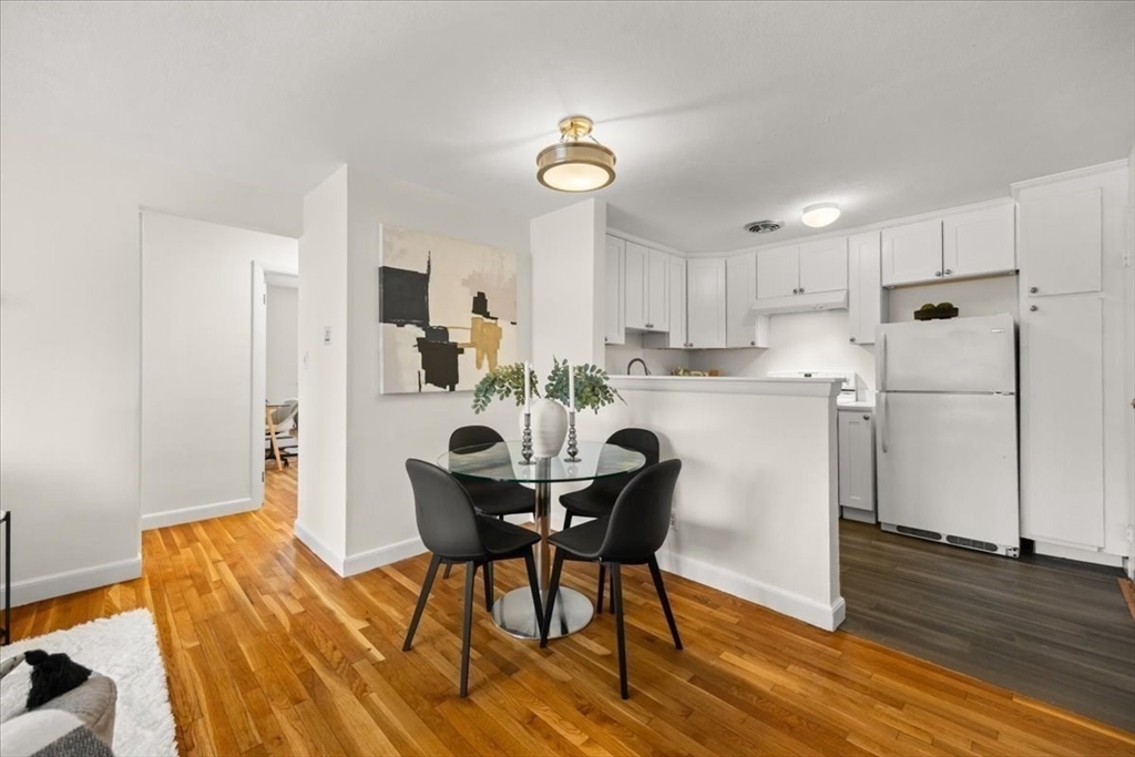 51 Warren Street, Unit 13 Waltham, MA 02453 - Photo 5 of 16 a view of a dining room with furniture and a wooden floor
