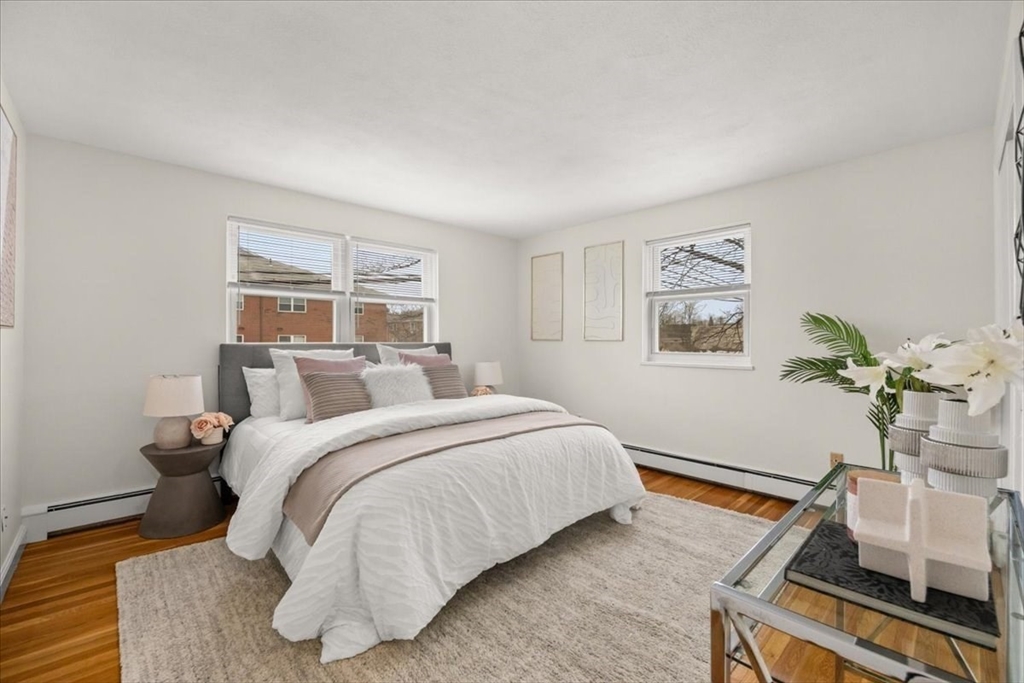 51 Warren Street, Unit 13 Waltham, MA 02453 - Photo 7 of 16 a bedroom with a bed and wooden floor