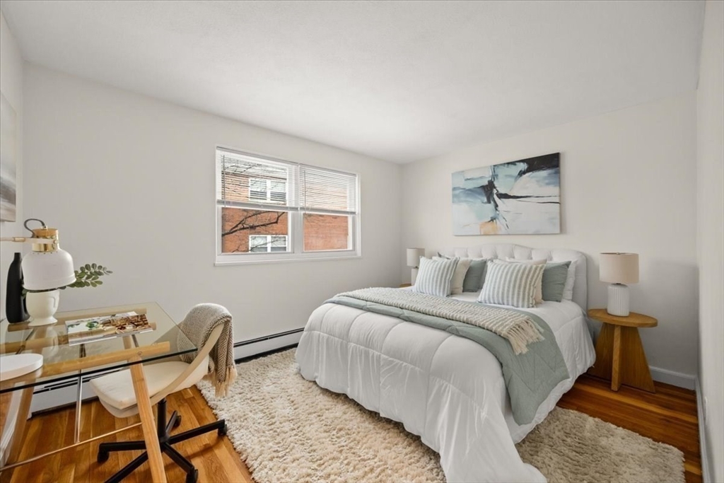 51 Warren Street, Unit 13 Waltham, MA 02453 - Photo 9 of 16 a bedroom with a bed and wooden floor