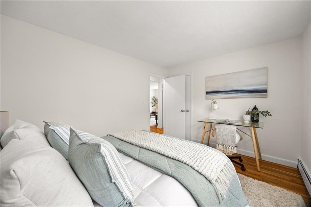51 Warren Street, Unit 13 Waltham, MA 02453 - Photo 10 of 16 a bedroom with a bed and wooden floor