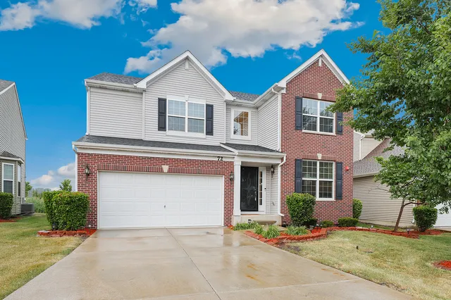 a front view of a house with a yard and garage