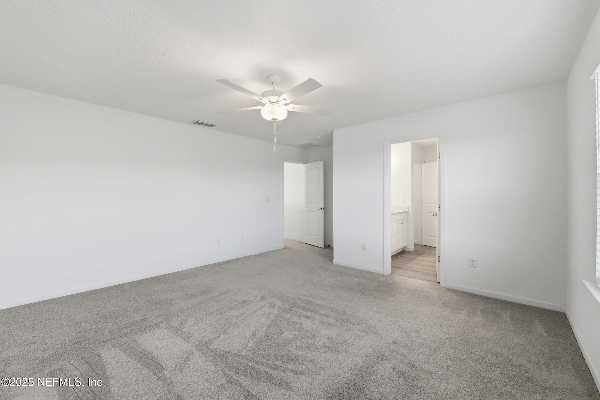 9852 Lemon Balm Way Jacksonville, FL 32219 - Photo 12 of 45 an empty room with a ceiling fan and a fan
