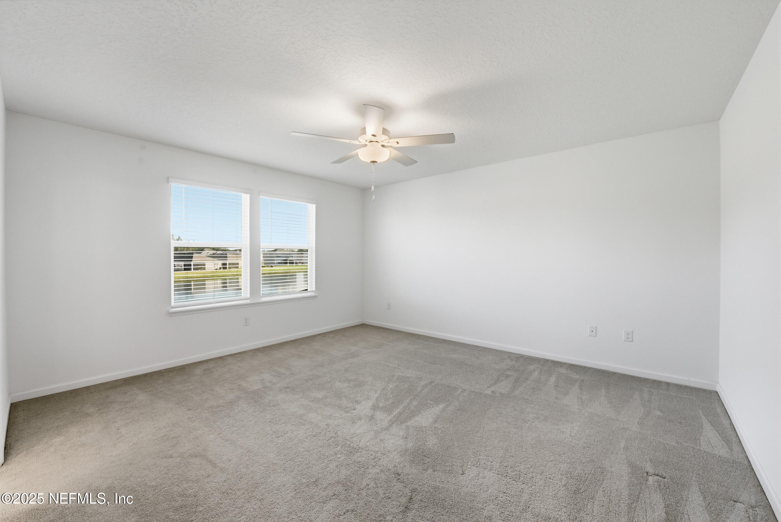 9852 Lemon Balm Way Jacksonville, FL 32219 - Photo 13 of 45 an empty room with a window and a ceiling fan