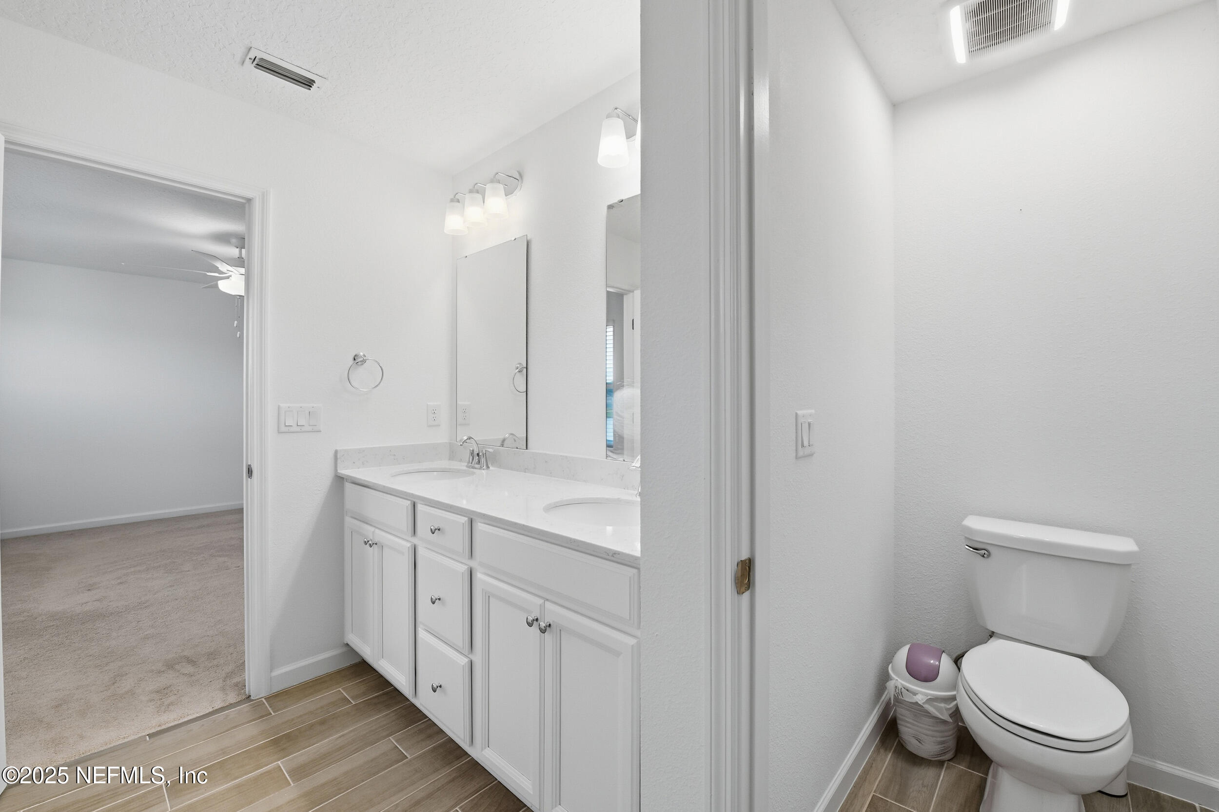 9852 Lemon Balm Way Jacksonville, FL 32219 - Photo 18 of 45 a spacious bathroom with a granite countertop toilet a sink and a mirror
