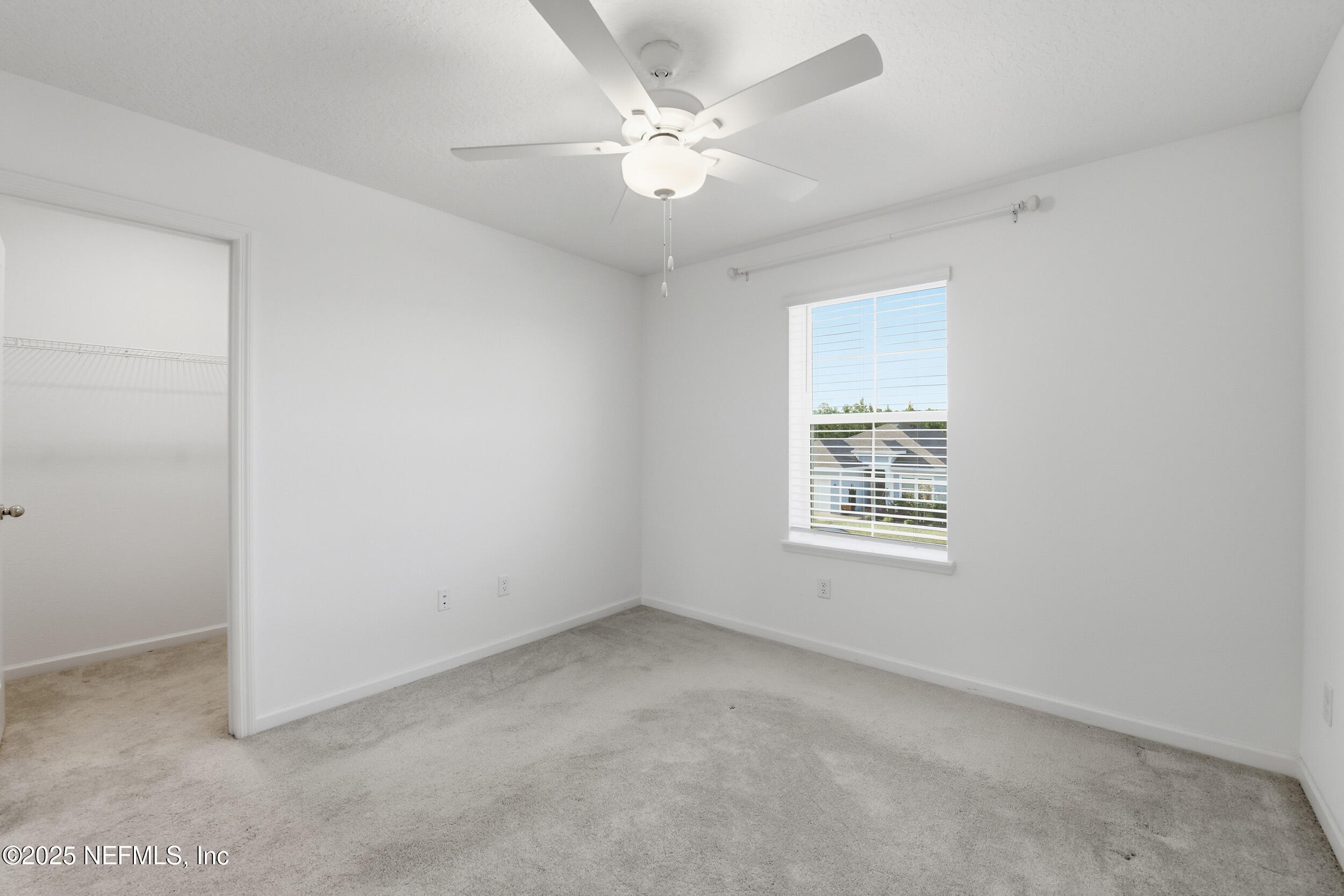 9852 Lemon Balm Way Jacksonville, FL 32219 - Photo 20 of 45 an empty room with a window and a ceiling fan