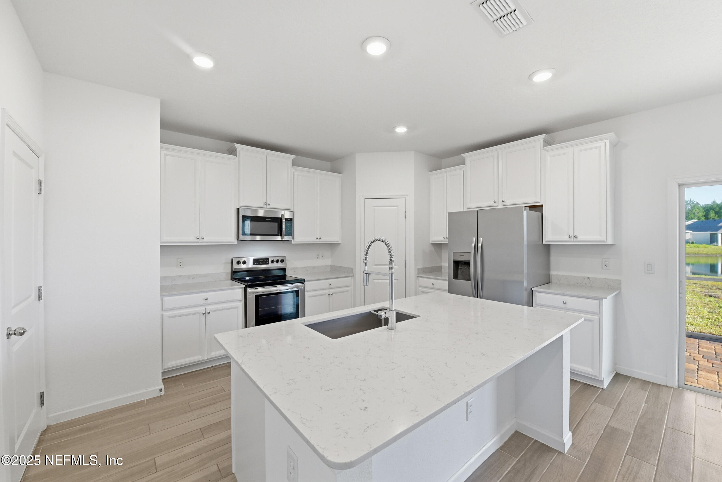 9852 Lemon Balm Way Jacksonville, FL 32219 - Photo 3 of 45 a kitchen with refrigerator cabinets and wooden floor