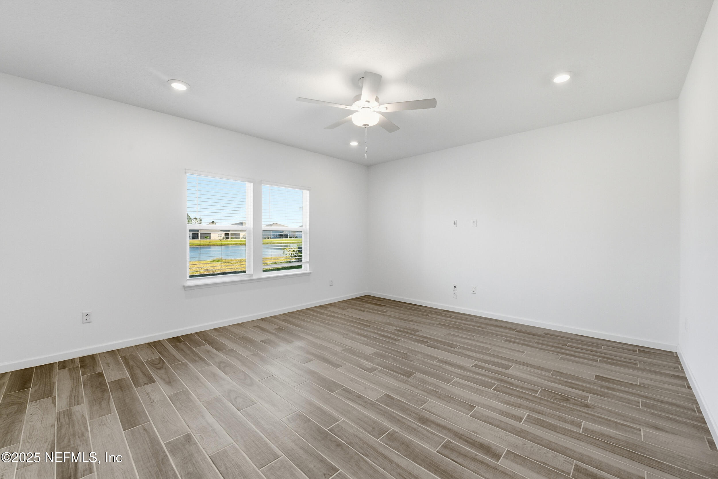 9852 Lemon Balm Way Jacksonville, FL 32219 - Photo 9 of 45 an empty room with wooden floor and windows