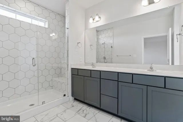 a bathroom with a double vanity sink mirror and shower