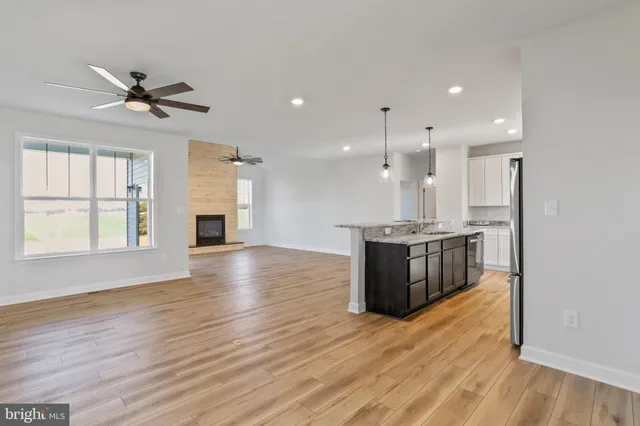 a kitchen with stainless steel appliances kitchen island granite countertop a stove and a wooden floors