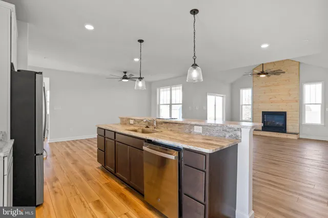 a kitchen with kitchen island a counter top space a sink appliances and cabinets