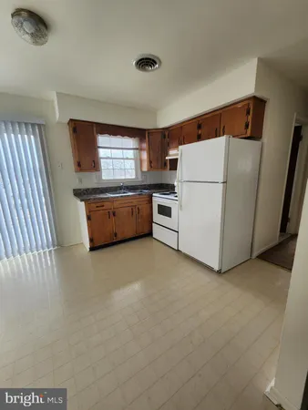 a kitchen with granite countertop cabinets a sink and white appliances