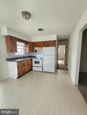 a view of a kitchen with stainless steel appliances granite countertop a refrigerator and a stove top oven