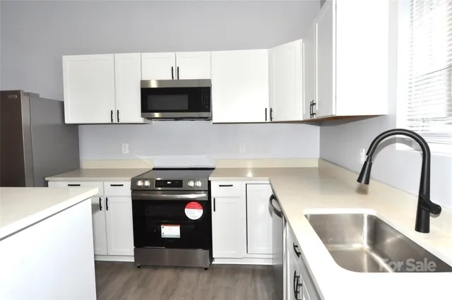 a kitchen with a sink a stove and microwave