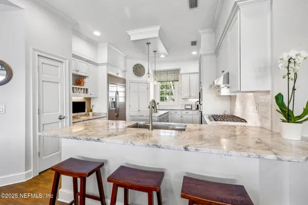 a kitchen with stainless steel appliances granite countertop white cabinets a stove a sink and dishwasher