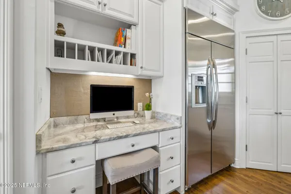 a kitchen with a stove a clock and cabinets