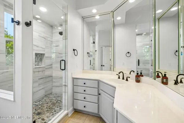 a bedroom with a large bed a large window and a flat tv screen